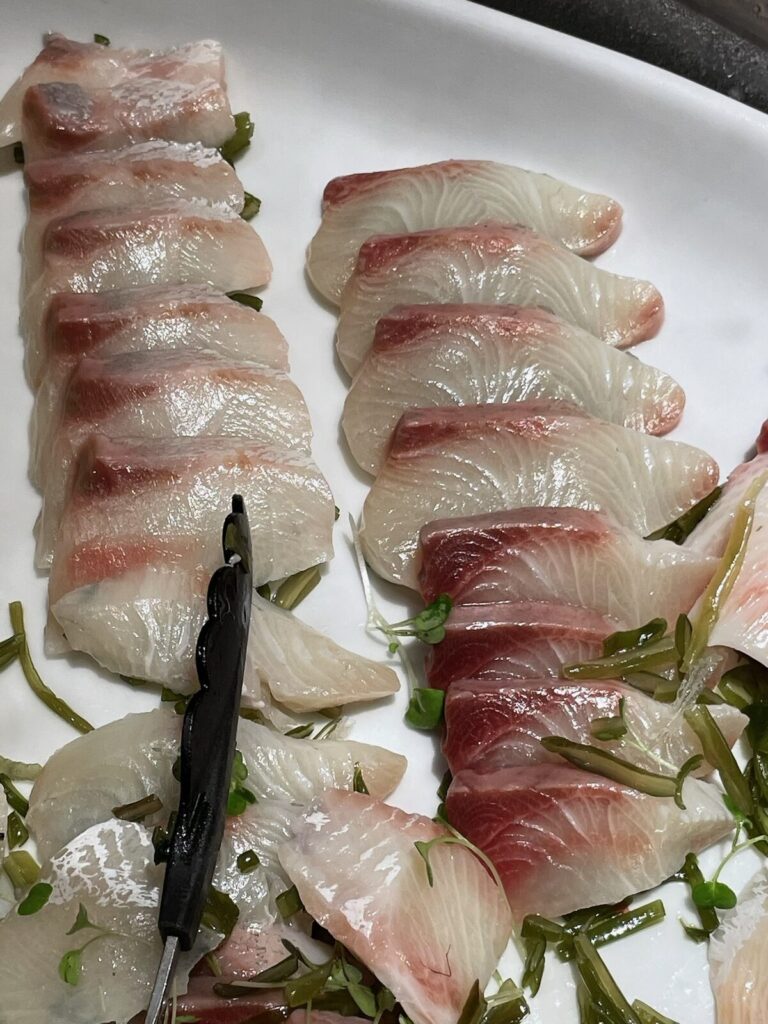 白い皿に盛られたブリのカルパッチョ 柚子胡椒風味