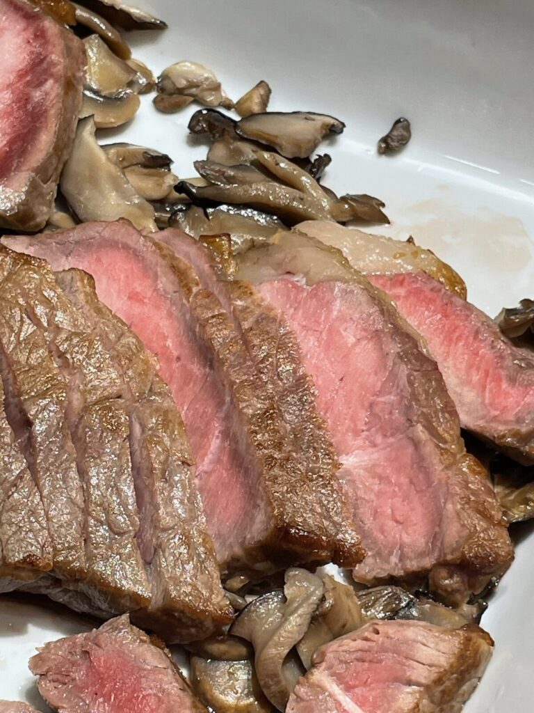 きのこを添えてスライスされた牛ロースのロースト