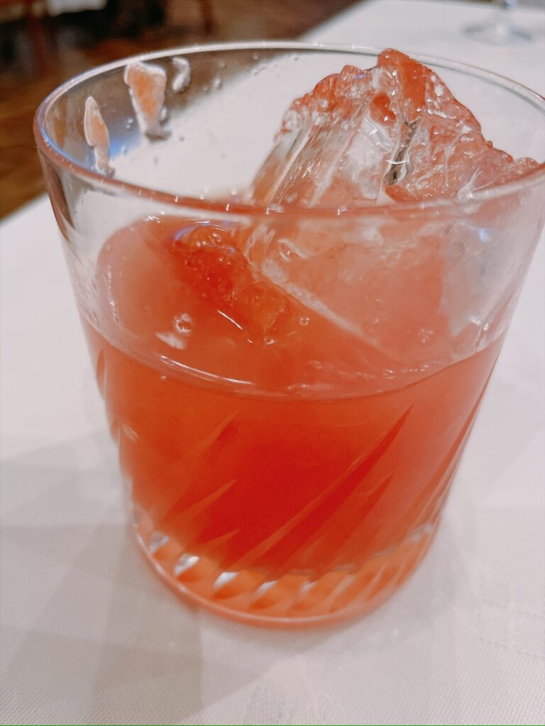 すいかの果肉が入ったピンク色のお酒のグラス