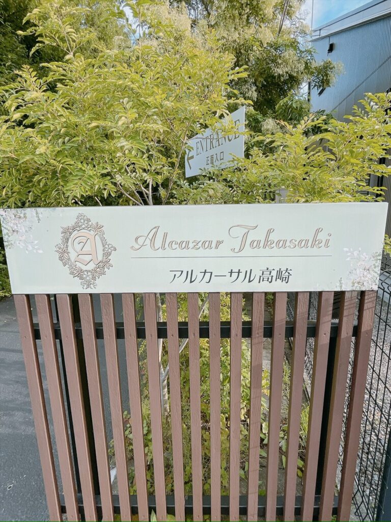 緑に囲まれたアルカーサル高崎の看板