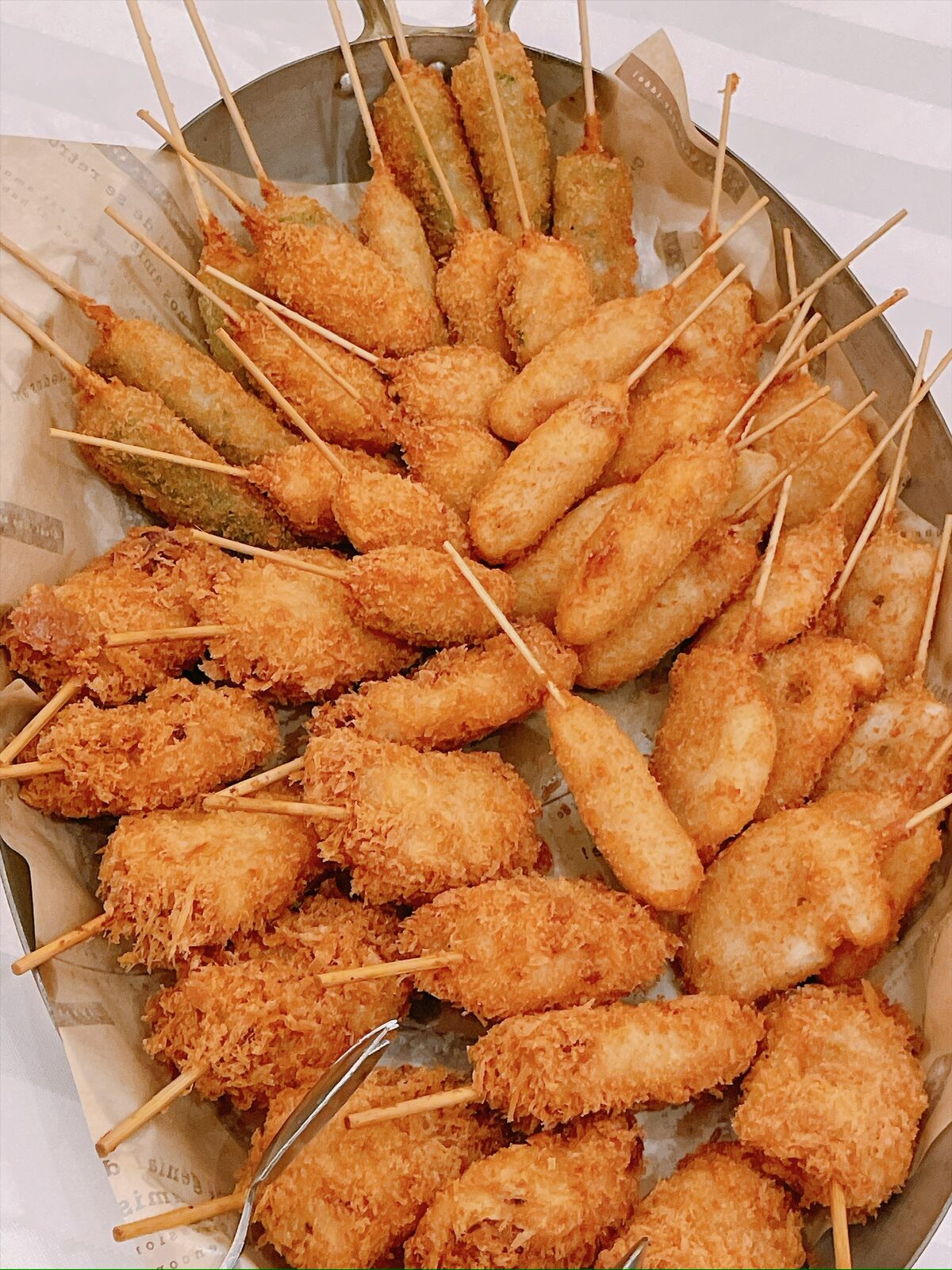 大皿に山盛りになった、串に刺した揚げ物