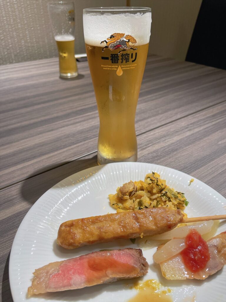テーブルに並ぶ生ビールと取り分けた料理