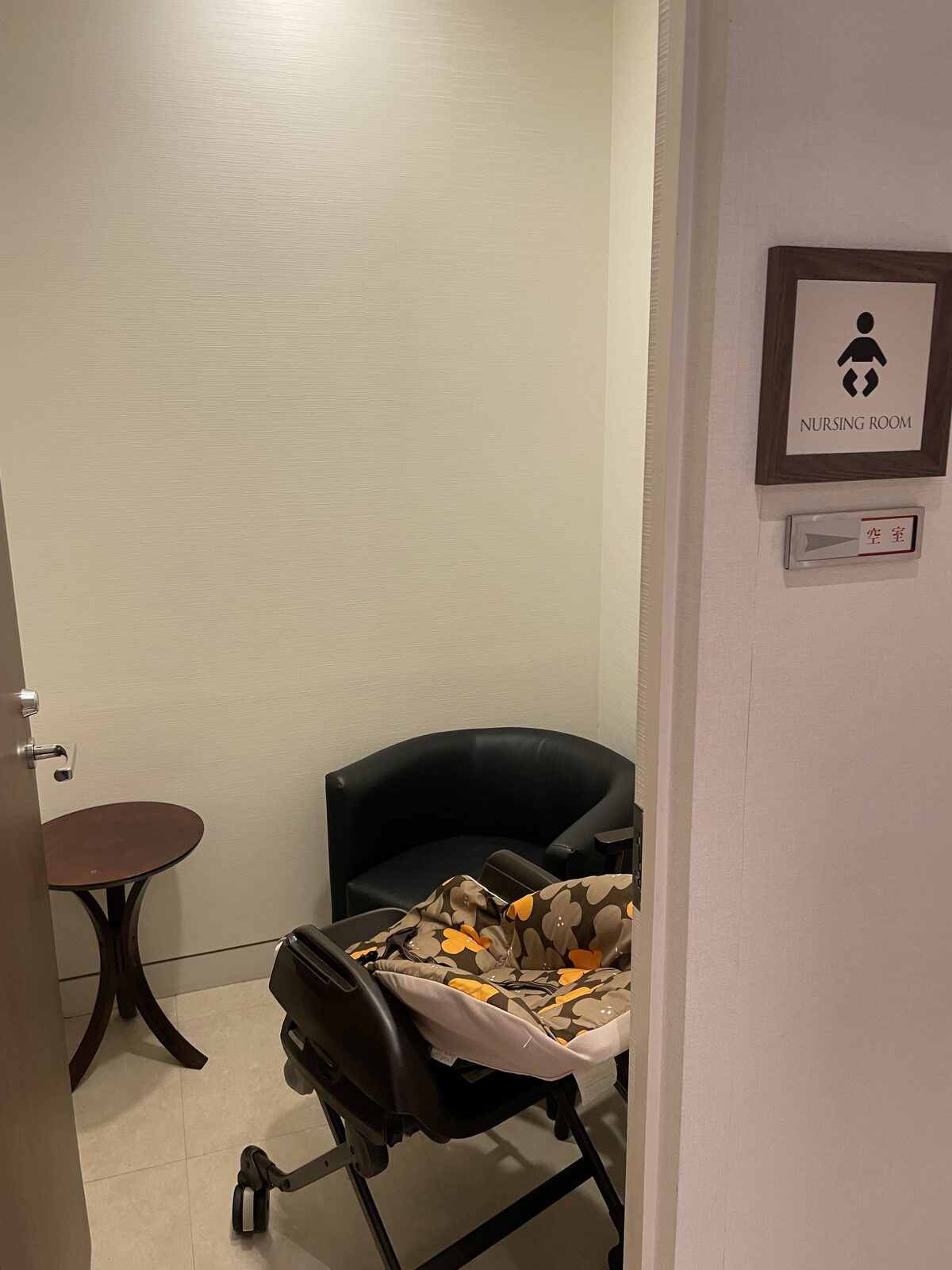 NURSING ROOM と書かれた札のある部屋。中にベビーラックと椅子が置かれている