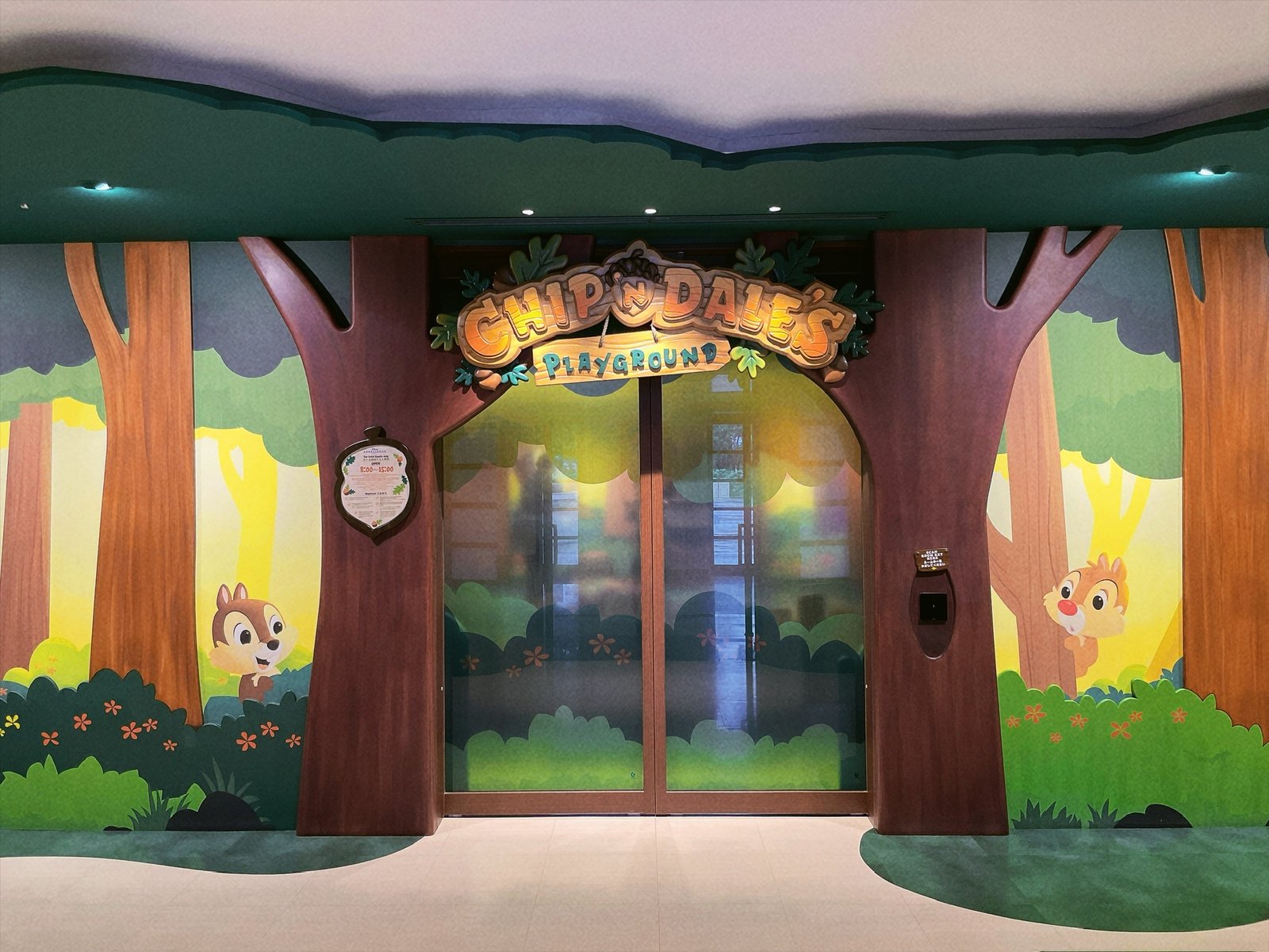 森をテーマにした部屋の入口。左手の木の幹に、どんぐりの形をした白い案内板が掛かっている