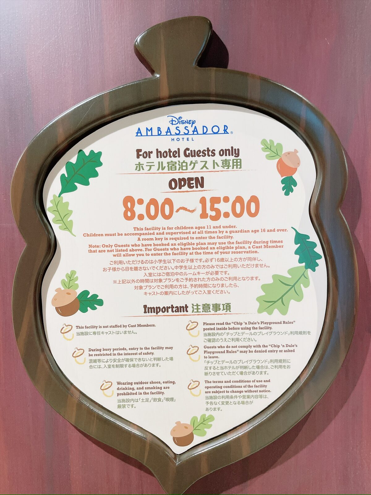 どんぐりの形をした白い案内板。緑の葉とどんぐりの絵が縁に描かれ、「For hotel Guests only ホテル宿泊ゲスト専用」「OPEN 8:00〜15:00」と大きく書かれている。その下に利用条件と注意事項が日本語と英語で並ぶ