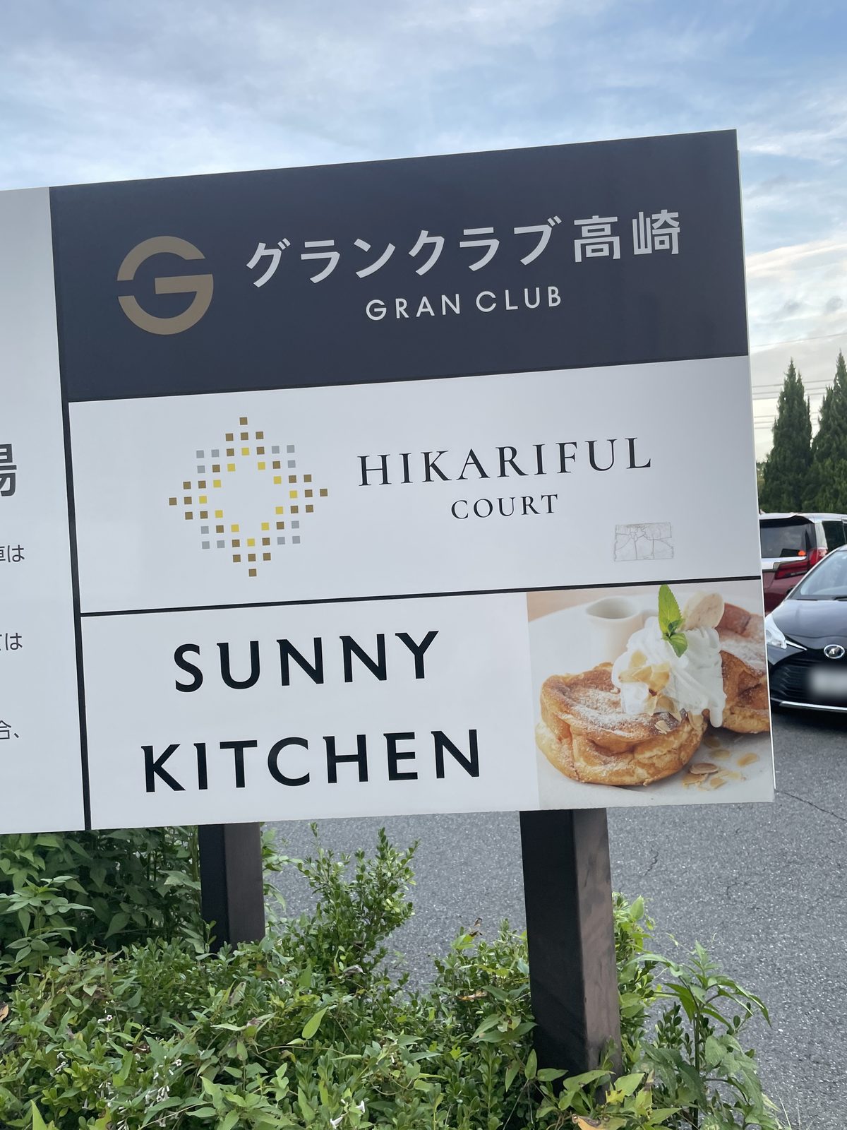「グランクラブ高崎」「HIKARIFUL COURT」「SUNNY KITCHEN」の3段に分かれた案内看板。右下にパンケーキの写真がある