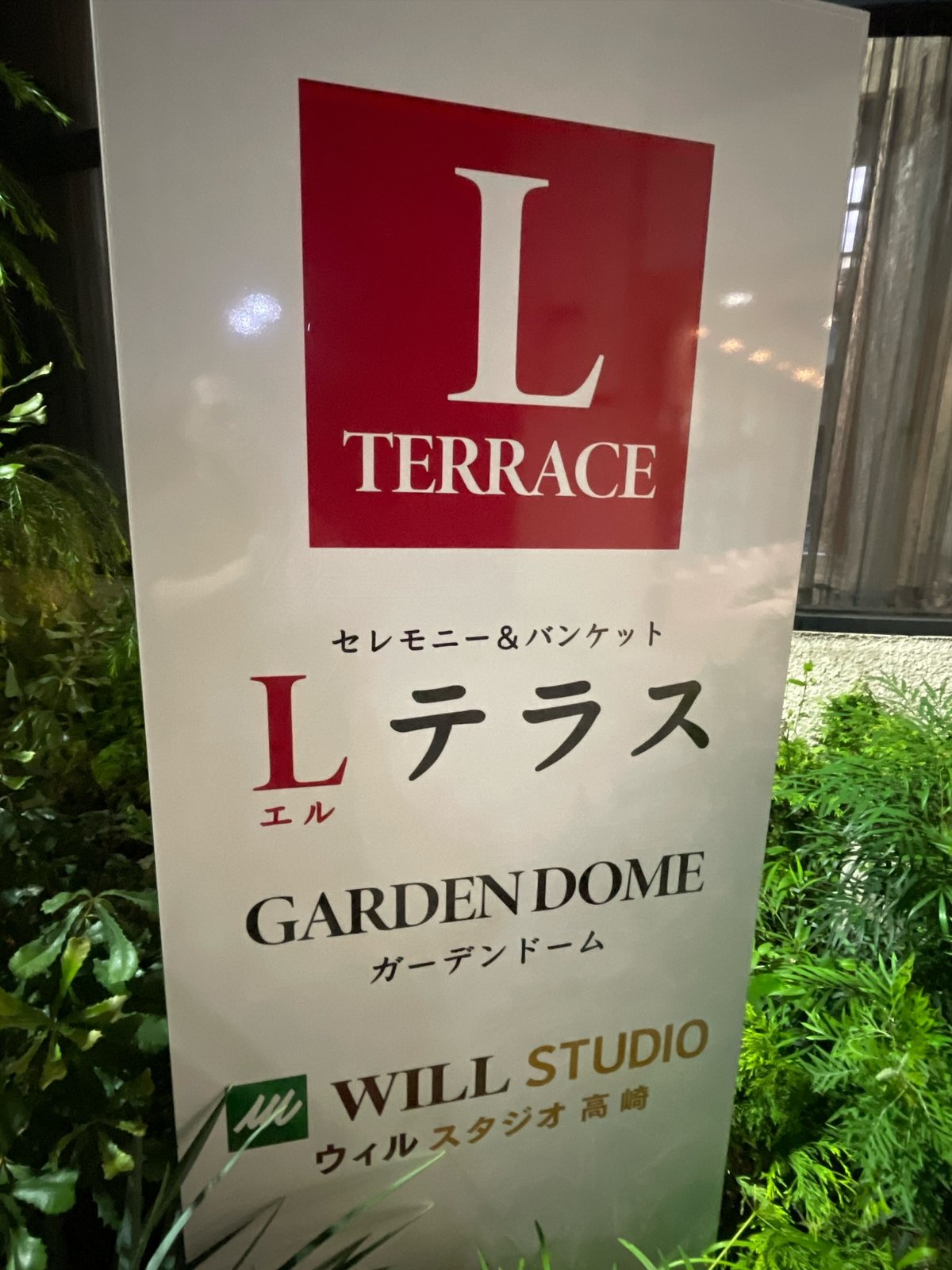 「L TERRACE」のロゴ、「セレモニー＆バンケット Lテラス」「GARDEN DOME ガーデンドーム」「WILL STUDIO ウィルスタジオ高崎」と書かれた白い立て看板