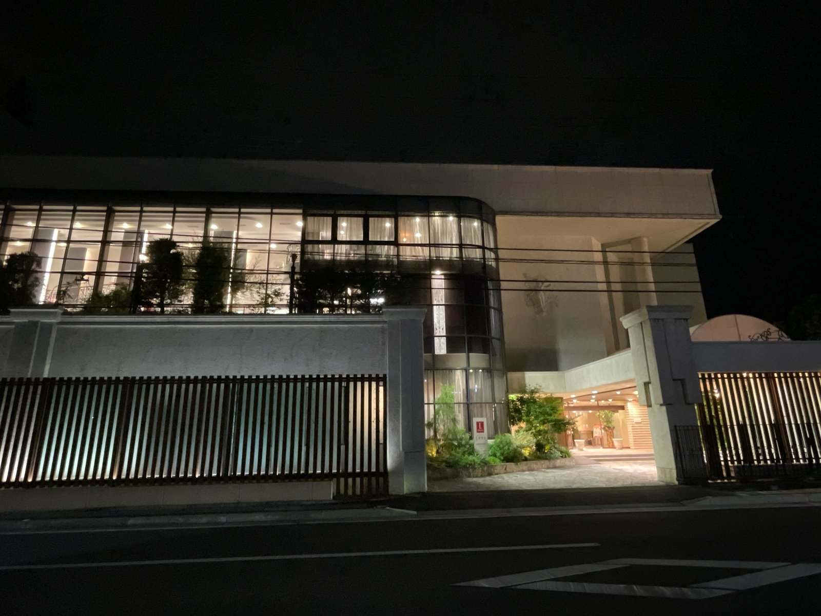 夜、通りから見たLテラスの建物。ガラス張りの2階に明かりがともっている