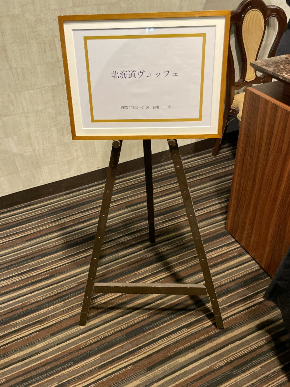 「北海道ヴュッフェ 時間 18時30分から21時 会場 3階 凛」と書かれた木枠の案内板