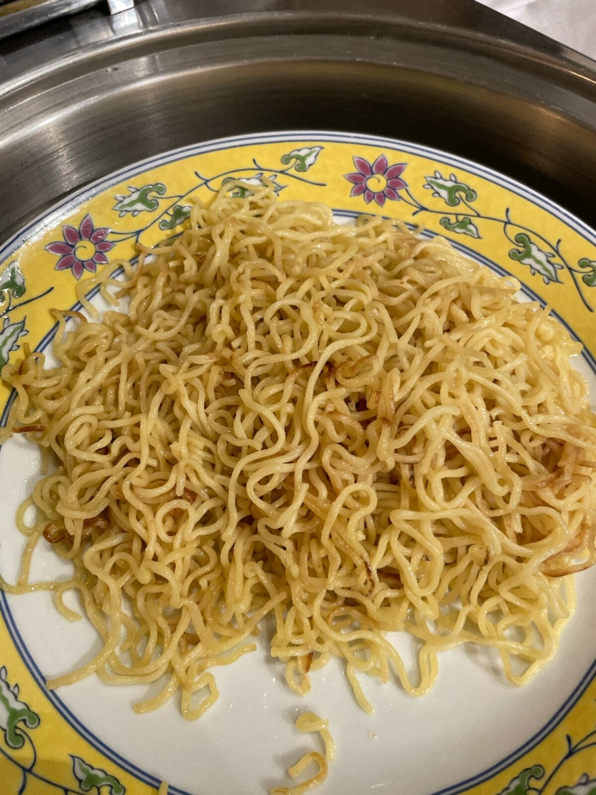 花柄の大皿に山盛りにした、焼き目のついた中華麺