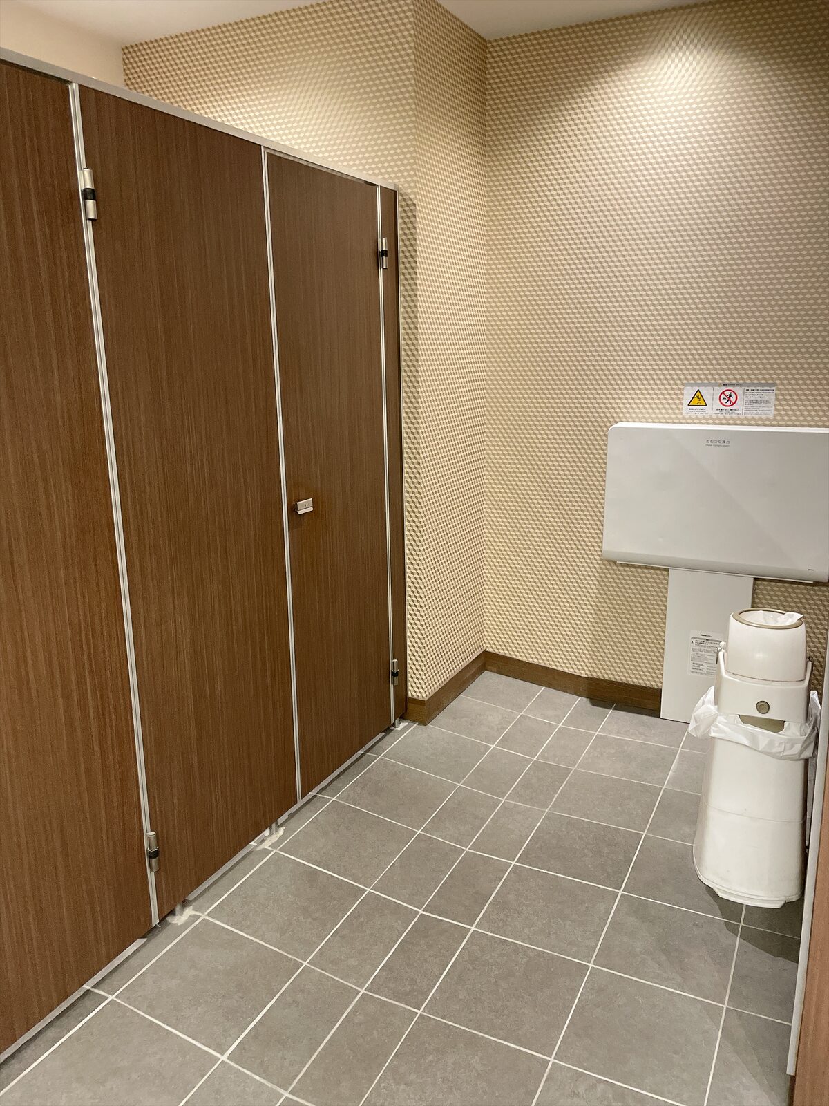 トイレの洗面スペースの壁に設けられた、折りたたみ式のおむつ交換台とダストボックス